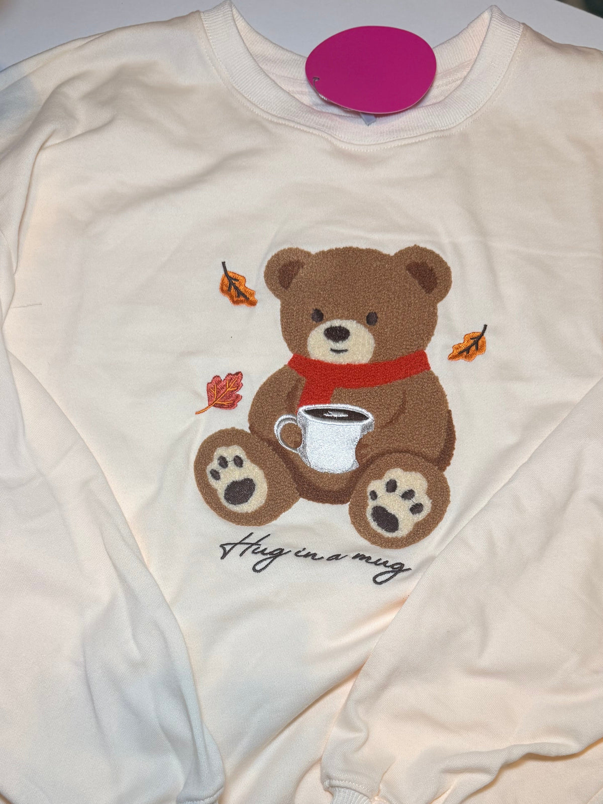 Cream crewneck sweatshirt showing full teddy bear and mug graphic