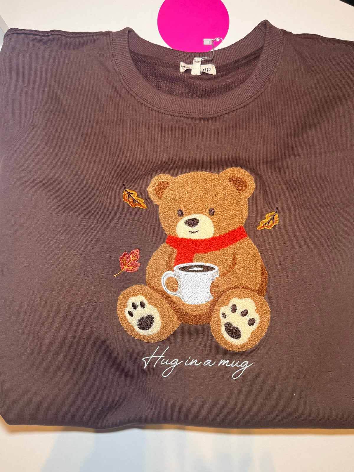 Model wearing brown Hug in a Mug teddy bear graphic sweatshirt