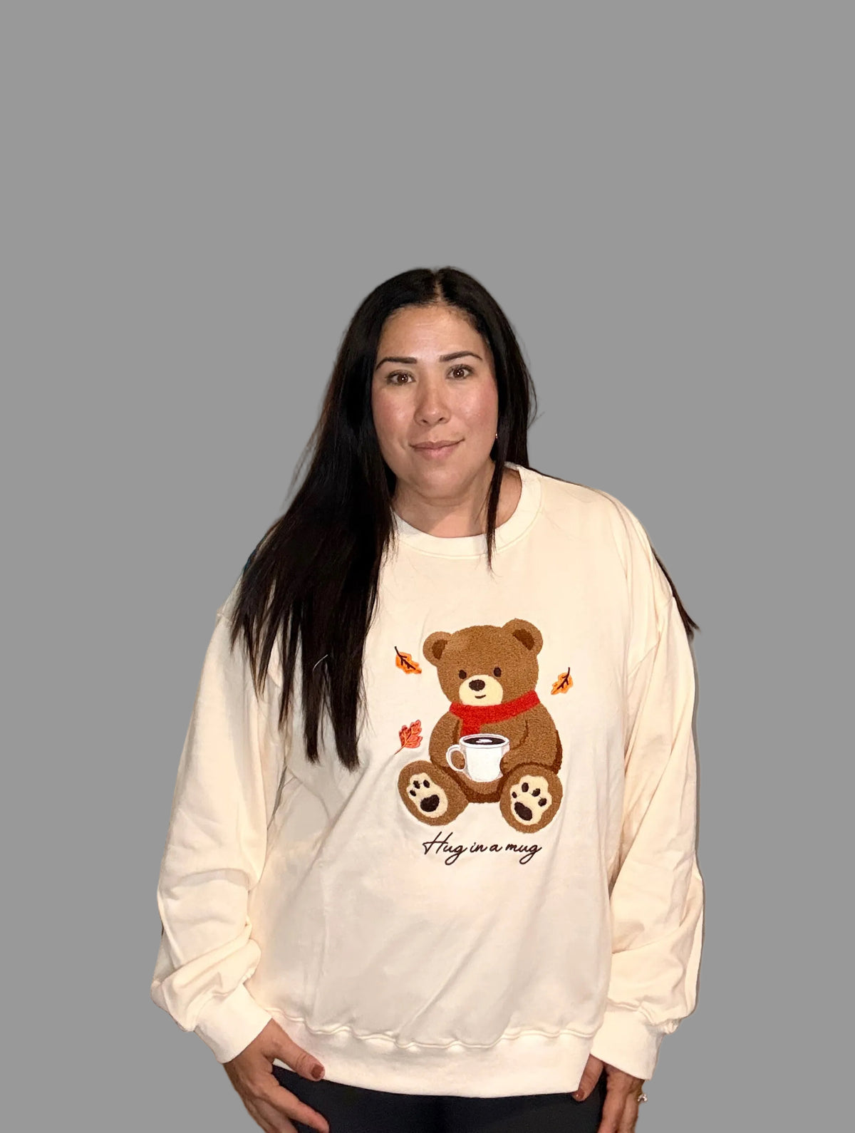 Front view of cream teddy bear graphic crewneck sweatshirt on model