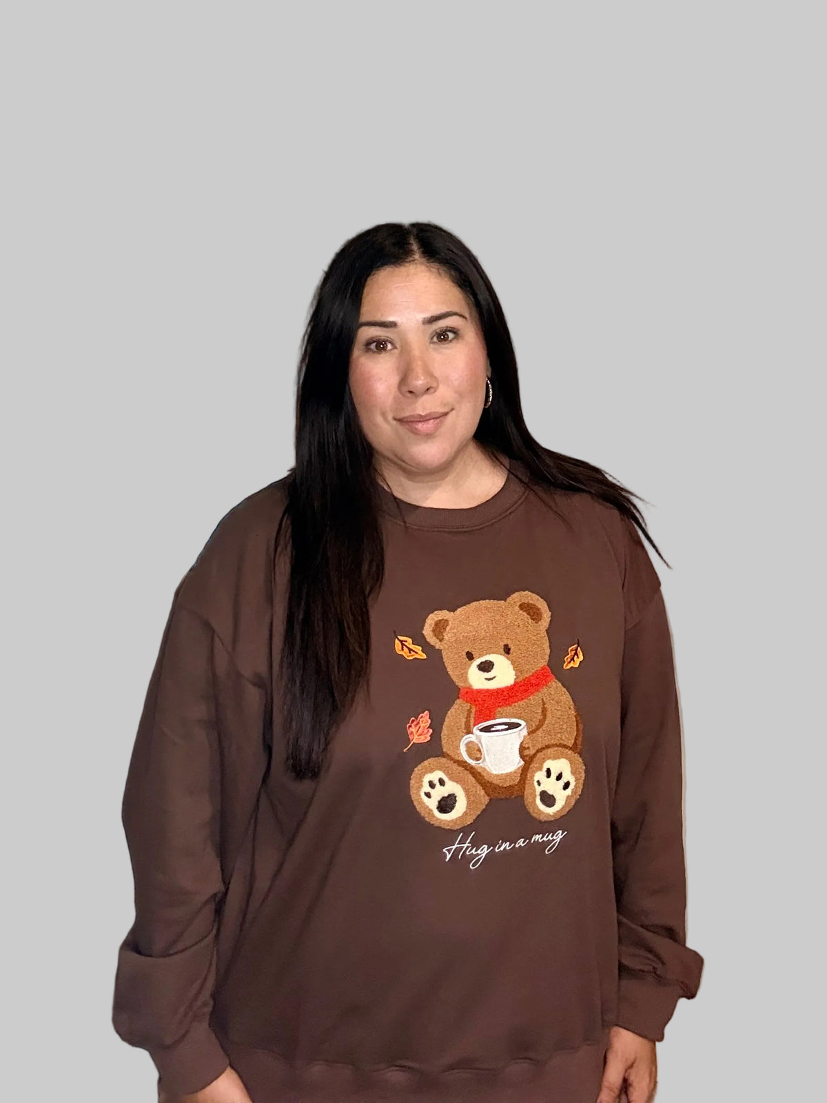 Front view of brown teddy bear graphic crewneck sweatshirt on model